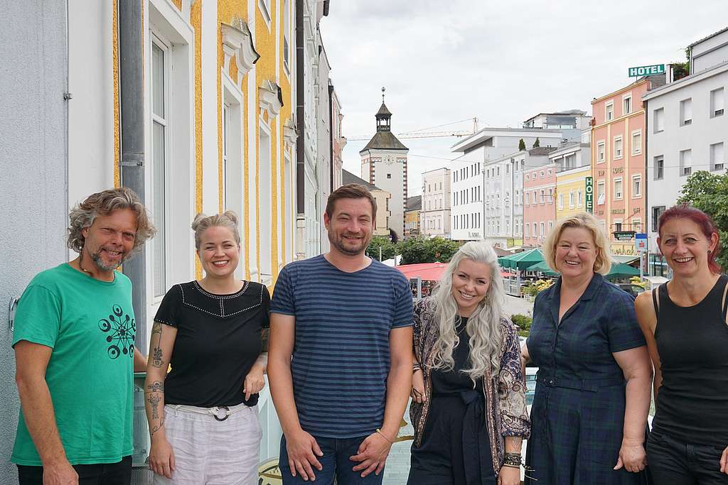 Gruppenfoto von sechs Personen, im Hintergrund der Stadtplatz Vöcklabruck