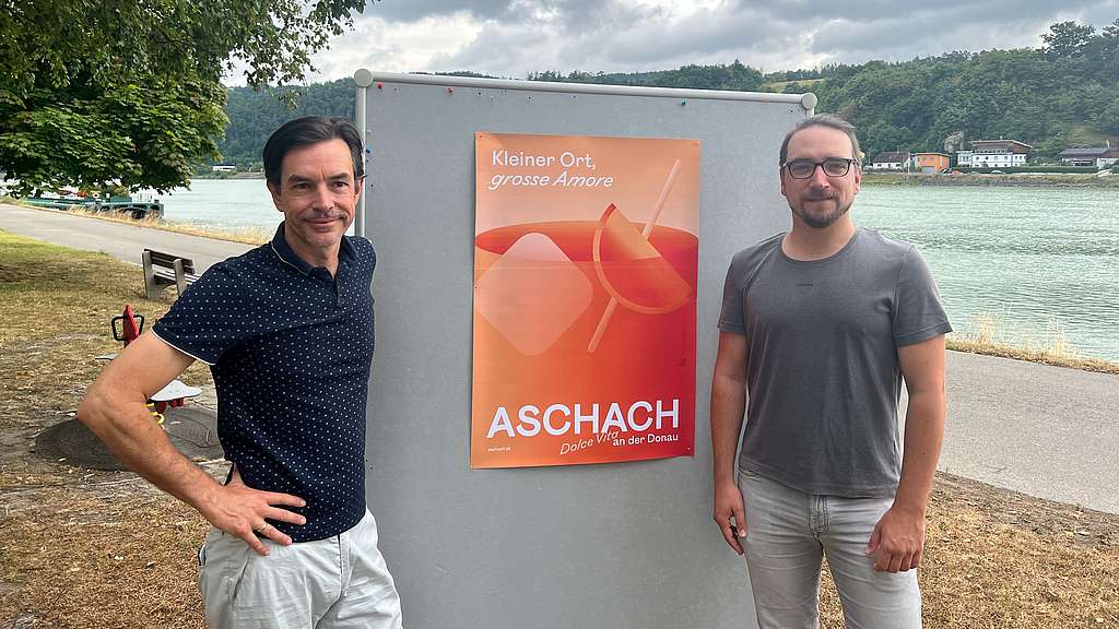 Projektleiter Wimmer und Bürgermeister Groiss mit Plakat vor der Donau