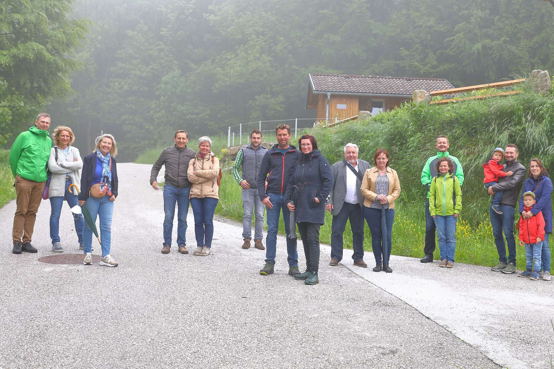 Gruppenfoto der Exkursion, 15 Personen  auf einer Strasse vor Wald