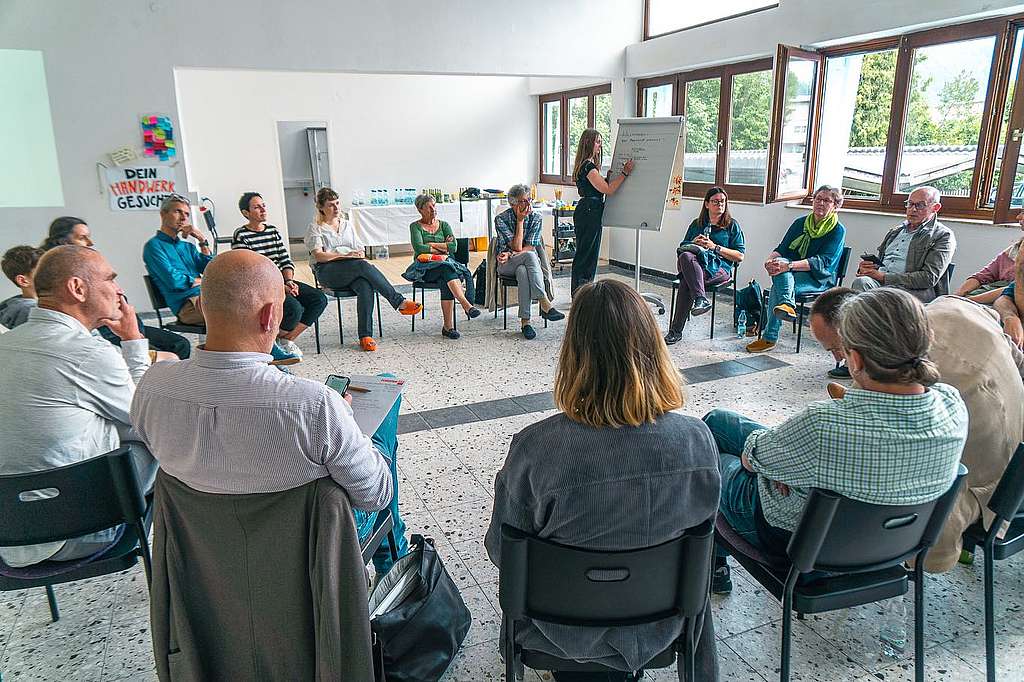 Workshop, ca. 30 Personen diskutieren in einem Sesselkreis sitzend