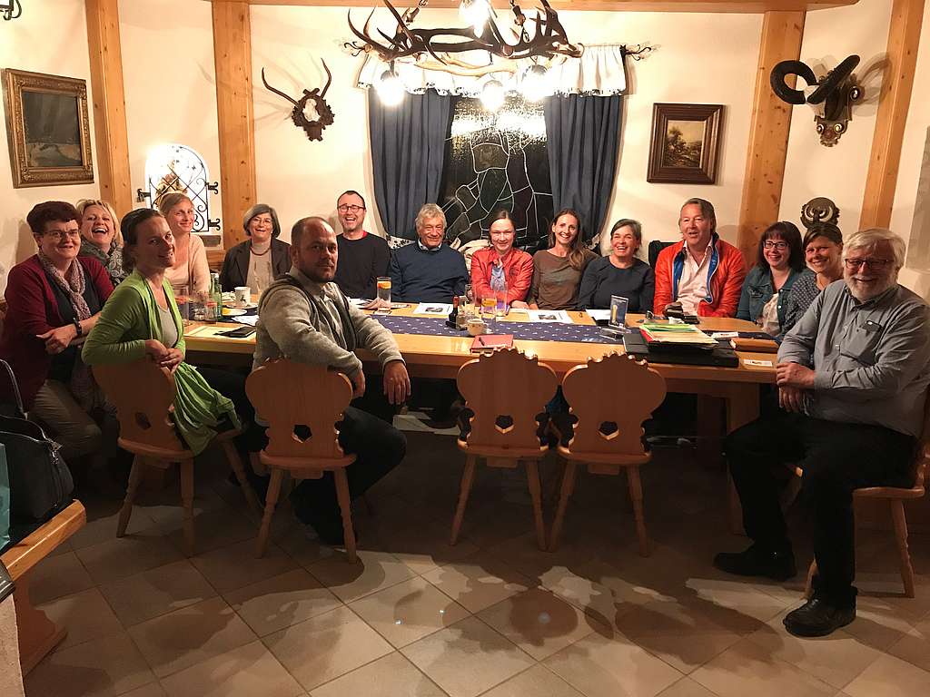 Gruppenbild der 15 Mitglieder des Kernteams an einem Tisch sitzend