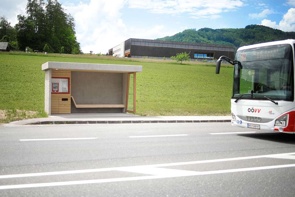 Ein Bus fährt an einer modern gestalteten Haltestelle vorbei.