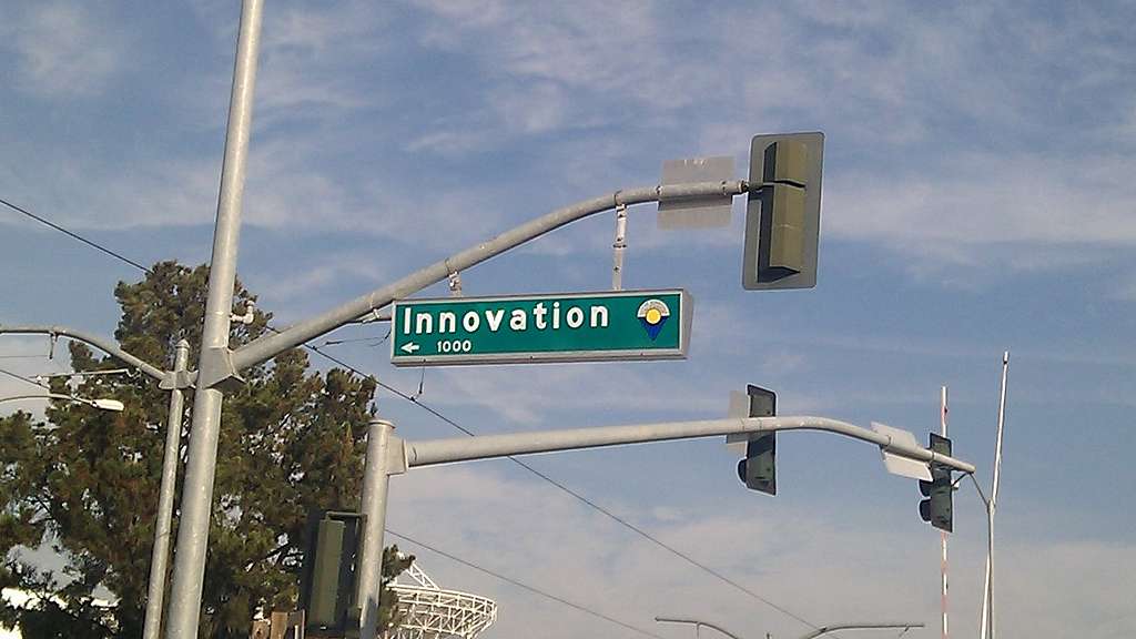 Schild mit Aufschrift "Innovation" an einer Ampel hängend