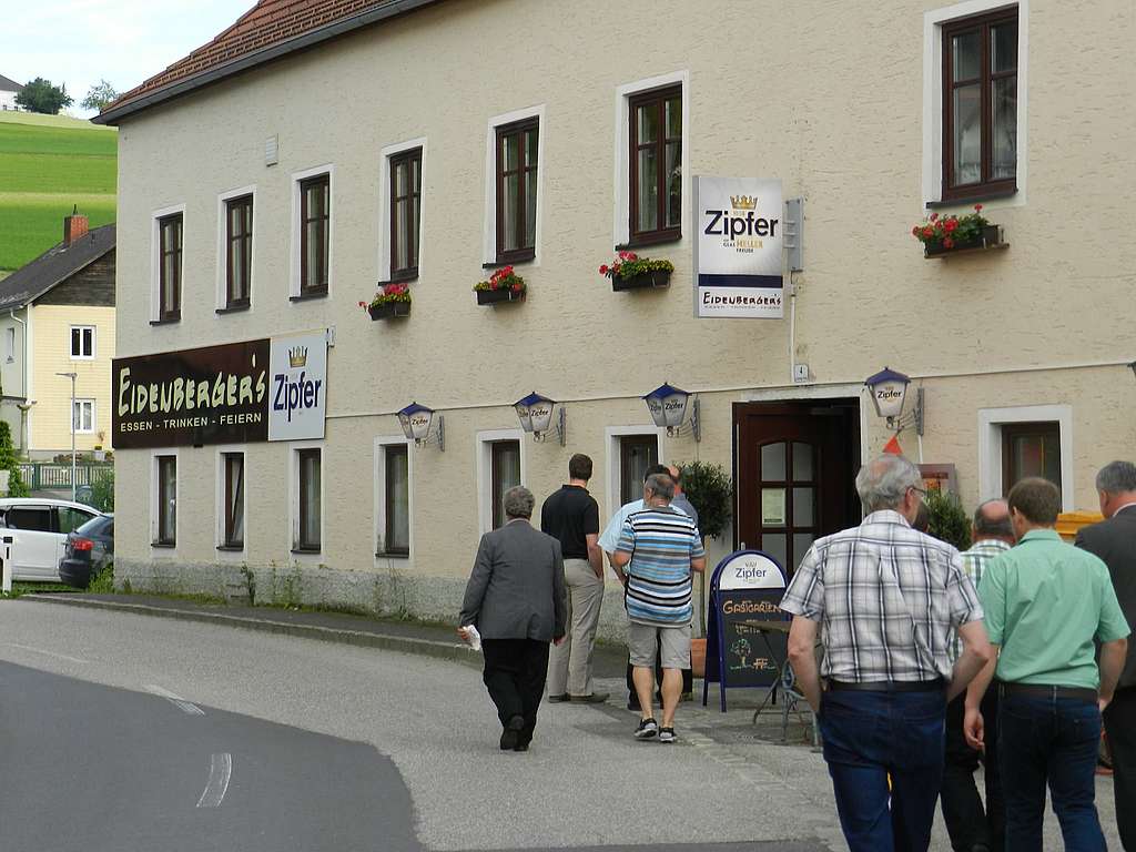 Eine Menschengruppe geht in Richtung Gasthaus Eidenbergers